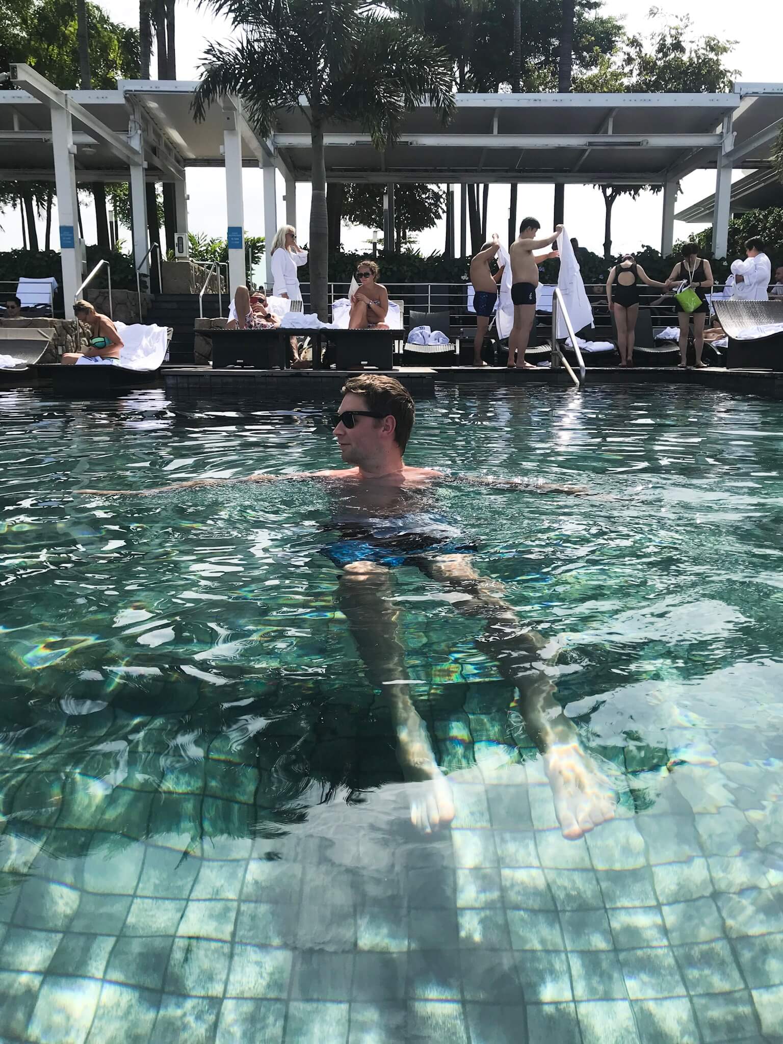 Jamie in the marina bay infinity pool facing the loungers