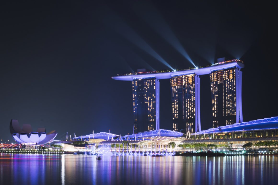 view of marina bay in Singapore at night with Marina Bay Sands hotel in the background. the spectra show is one of the best things to do in singapore especially when you only have one day