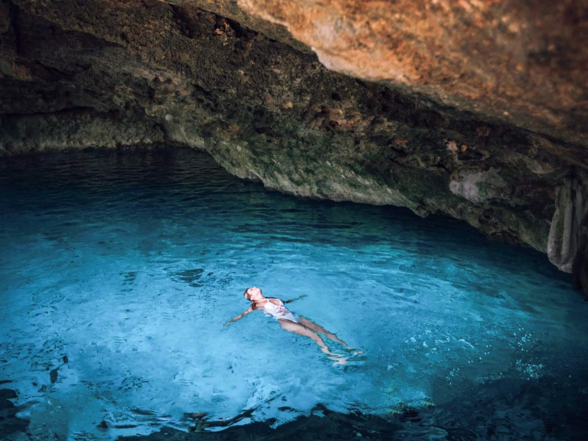 a woman swimming in cenotes Dos Ojos in the Riviera Maya, Mexico