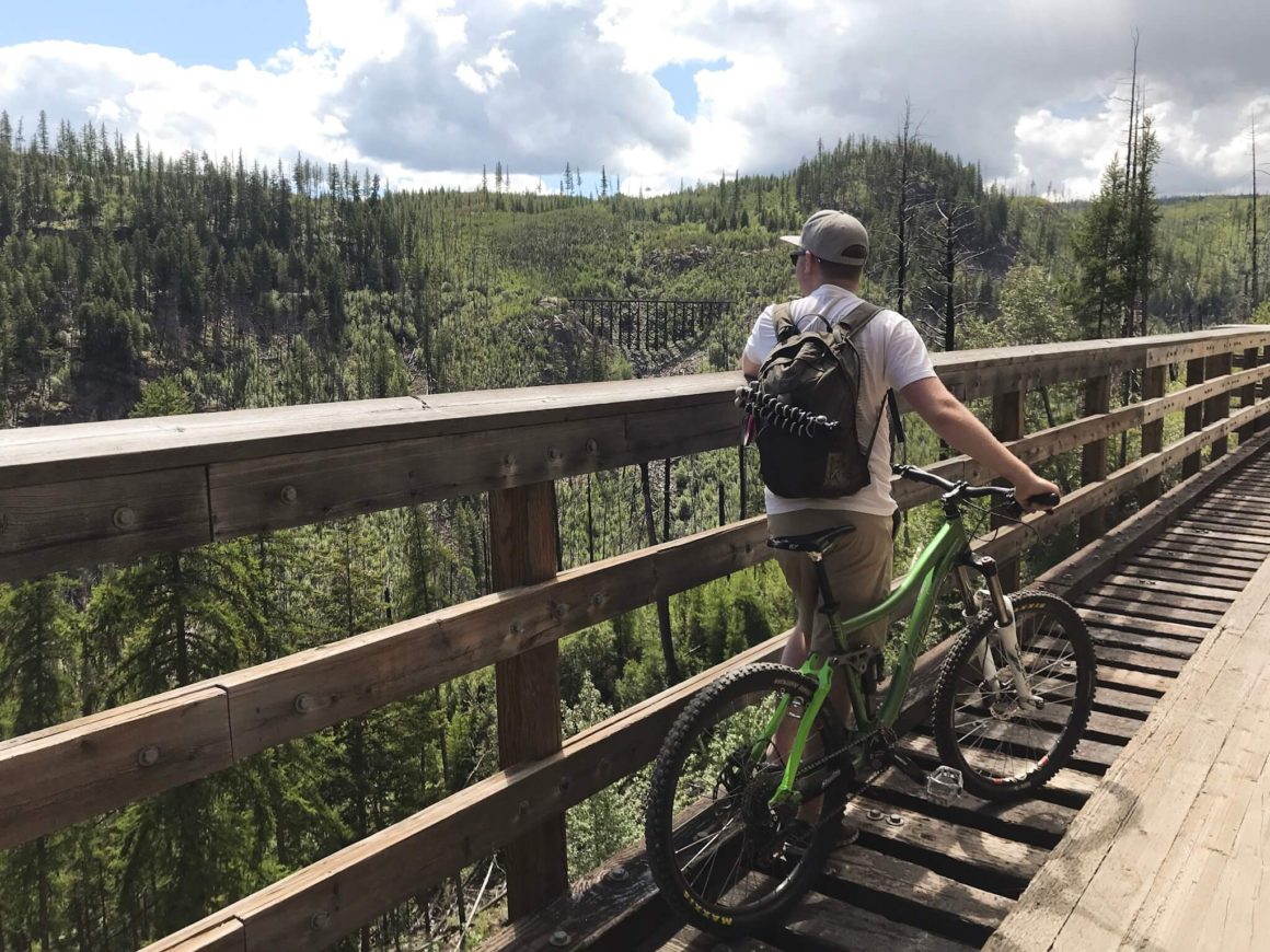 Jamie looking at the canyon view over to another train trestle from Myra Canyon trestles in kelowna